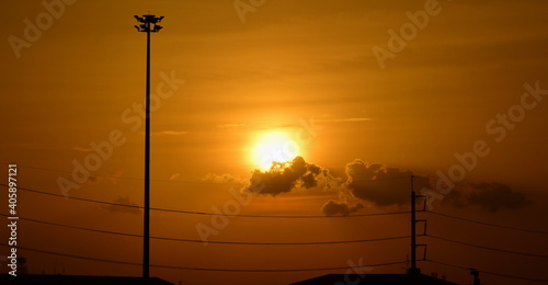 Sunset view Beautiful golden yellow sky in big cities,Power transmission system With the sky and the beautiful clouds in bright days.Golden sunset with poles and power lines