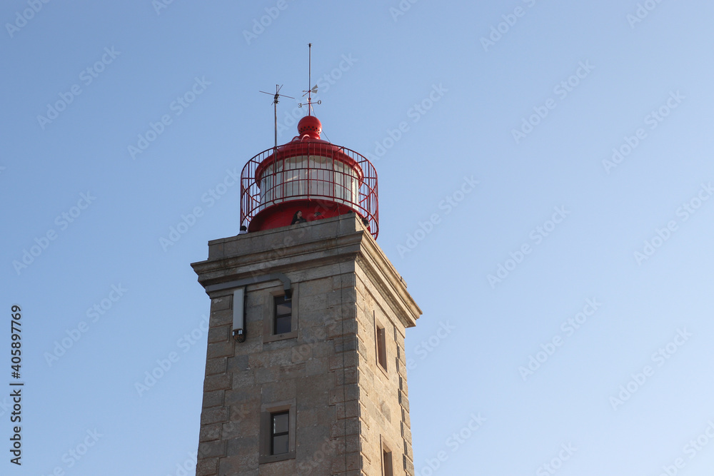 red round lighthouse top on a square stone tower