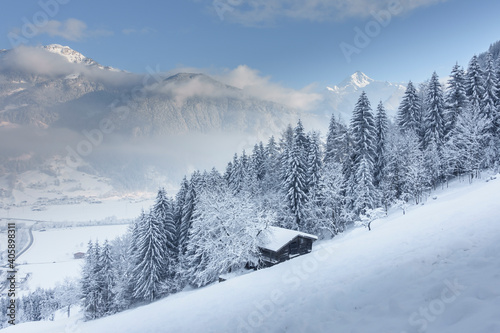 Berghütte im verschneiten Zillertal mit Blick ins Tal photo