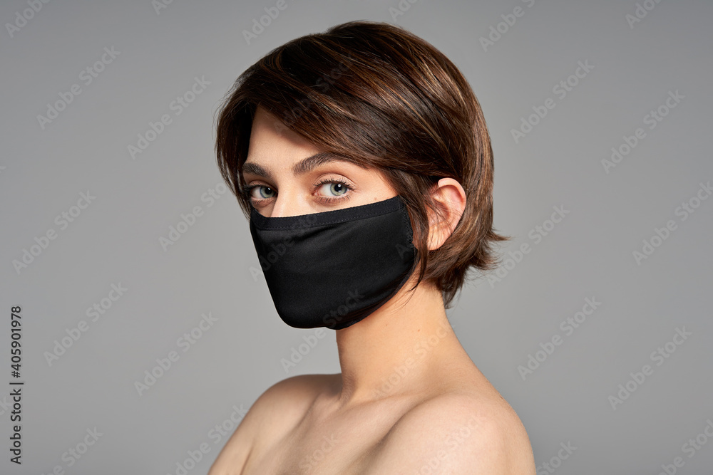 Close-up portrait of girl with protection flu cold facial mask isolated over gray background Close-up portrait of girl with protection flu cold facial mask isolated over gray background