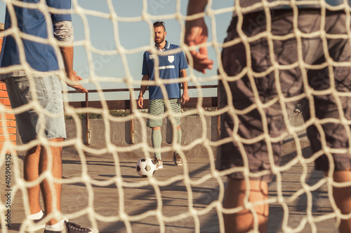 Man doing a free kick while playing football with friends