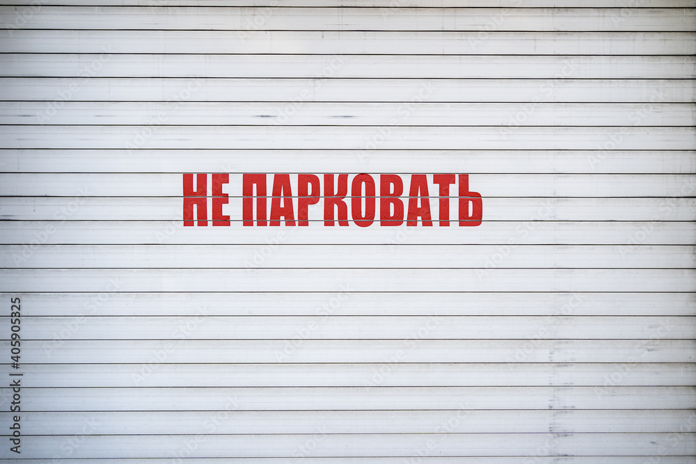 White iron tin fence lined background with russian inscription. Metal texture White iron tin fence lined background with russian inscription. Metal texture