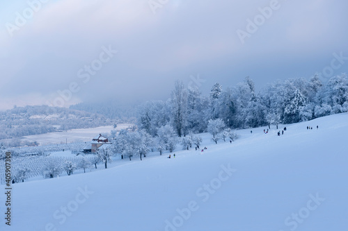 Blick vom Schönberg zum Jesuitenschloss. Wunderschön verschneite Landschaft in der blauen Stunde fotografiert. Im Vordergrund einige Freizeitsportler