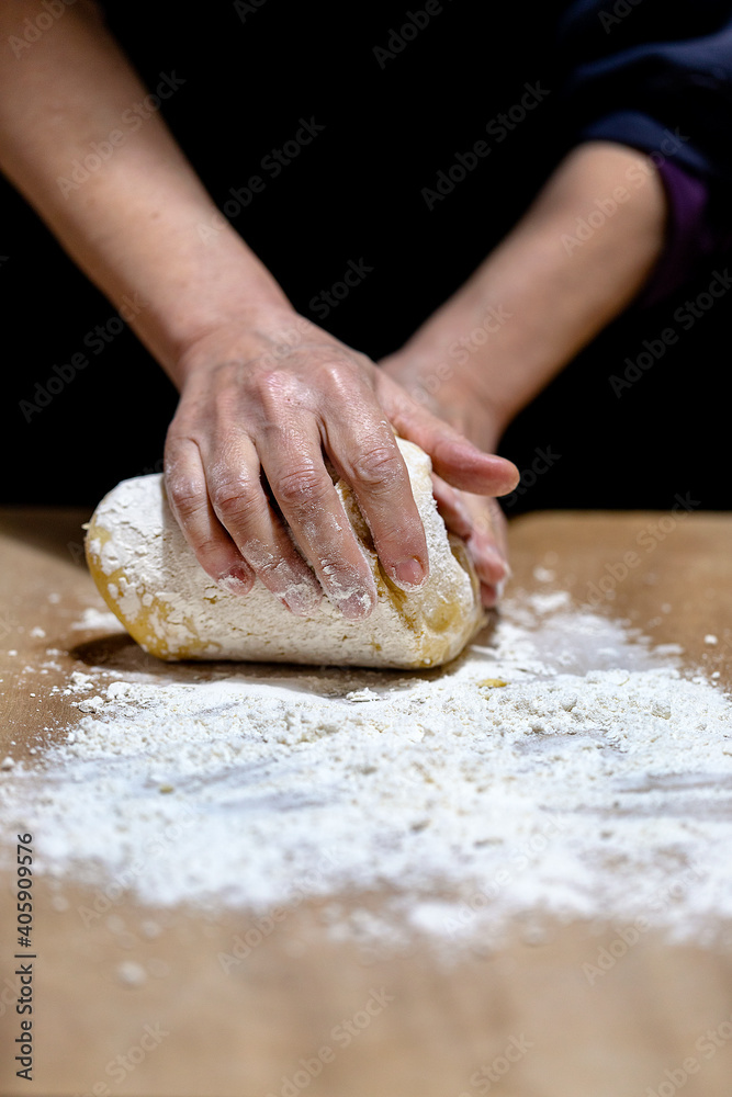 Two female hands kneading dough.