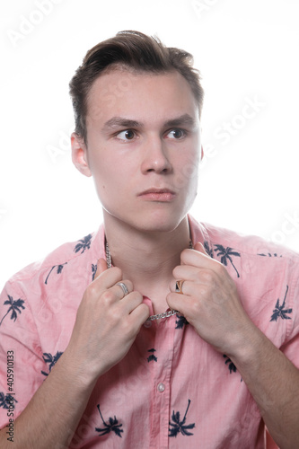 a white man in a pink shirt on a white background looks pathetically to the side photo