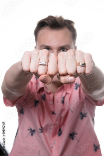 a white man in a pink shirt on a white background looks pathetically to the side photo