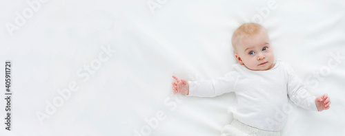Cute caucasian baby girl, looking at camera, white clothes on white background. Copy space for text, banner.