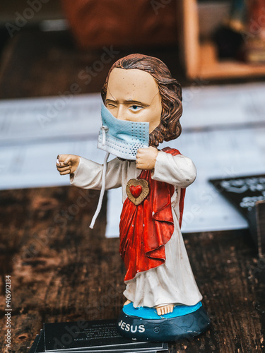 Vertical closeup of Jesus Christ figure wearing a mask-concept COVID19 pandem photo