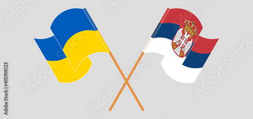 Crossed and waving flags of Ukraine and Serbia