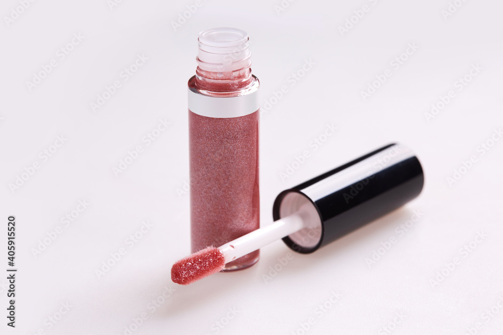 Tube of liquid lipstick gloss with applicator isolated on white background
