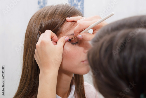 The process of creating makeup. Makeup artist working with a brush on the face of the model.