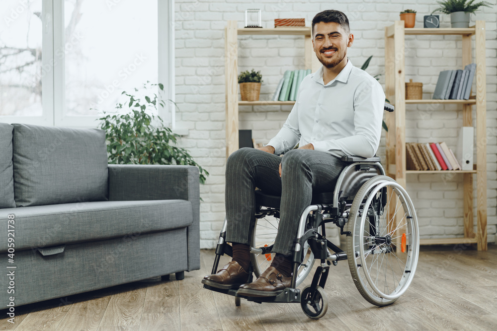 Happy smiling young man in a wheelchair at home Happy smiling young man in a wheelchair at home