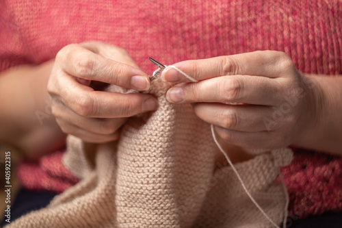woman hands knitting wool yarn with knitting needles 