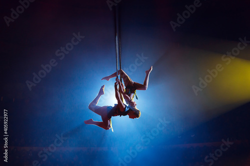 Circus actress acrobat performance. Two boys perform acrobatic elements in the air.