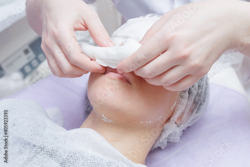 A cosmetologist does an ultrasonic cleaning of the skin of the face. photo