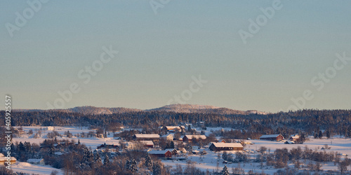 View of Kolbu at Toten in winter, with Tjuvåskampen Hill, part of the Totenåsen Hills, in the background.