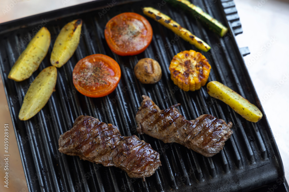 Electric grill with roast beef, spicy potatoes, mushrooms and vegetables Electric grill with roast beef, spicy potatoes, mushrooms and vegetables