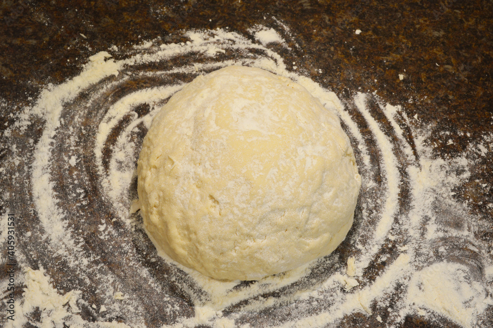 a large ball of yeast dough lies on a table sprinkled with abundant wheat flour a large ball of yeast dough lies on a table sprinkled with abundant wheat flour