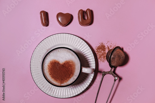 handmade chocolate candies and coffee sprinkled with cacao in heart shape on pink backdrop, i love you shape confectionery mold. concept for Valentine's Day, wedding, anniversary, Love symbol.