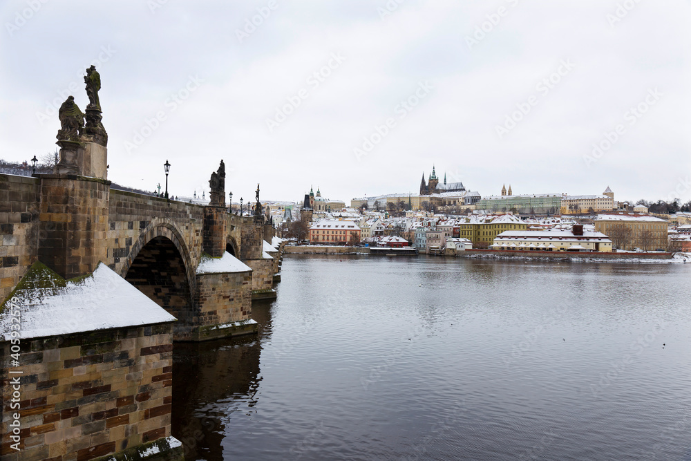 Fototapeta premium Snowy Prague Lesser Town with Prague Castle and Charles Bridge above River Vltava, Czech republic