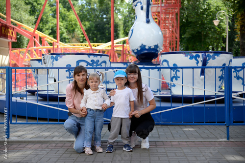 two families walk with children in a park near attractions.
