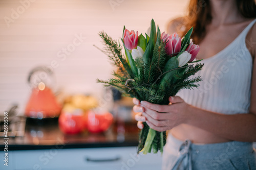 A bouquet of flowers in the hands of a woman. International Women's Day