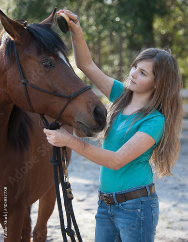 Tween age girl bonding with Arabian horse mare.