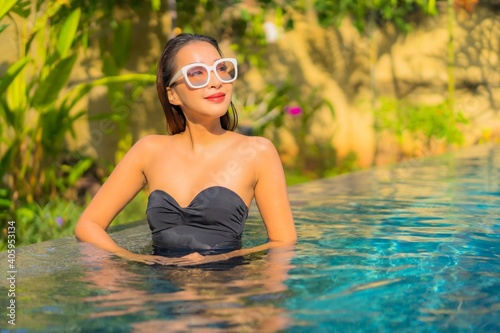 Portrait beautiful young asian woman enjoy relax around swimming pool