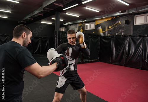 Male fighter practicing punches wearing boxing gloves