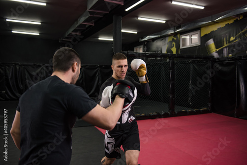 Male fighter practicing punches wearing boxing gloves