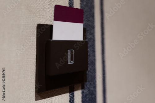 Tarjeta roja y blanca insertada en una ranura para entrar a la habitación de un hotel 