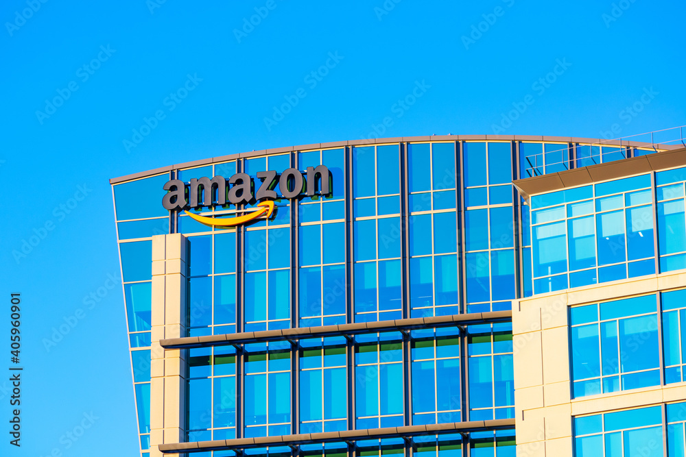 Amazon logo, sign its signature orange smile on the glass exterior of e