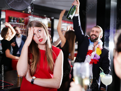 Photography Offended young woman on background with drunk man on party at a nightclub