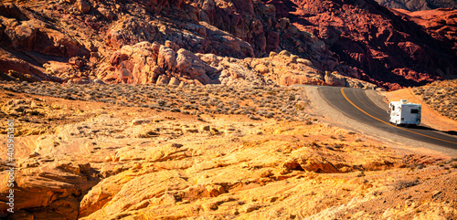 Photography A white motor home disappears over a ridge of red rocks in Valley of Fire State Park, northeast of Las Vegas, Nevada