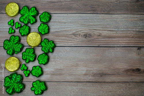 Glitter Covered Four Leaf Clovers Filling Half the Frame on a Wood Background