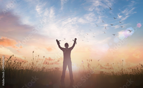 International human rights day concept: Silhouette slave hands broken chains with bird flying against twilight sky and meadow sunrise background