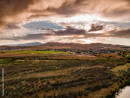 Dramatic rain clouds at sunset over a suburban area and mountain landscape