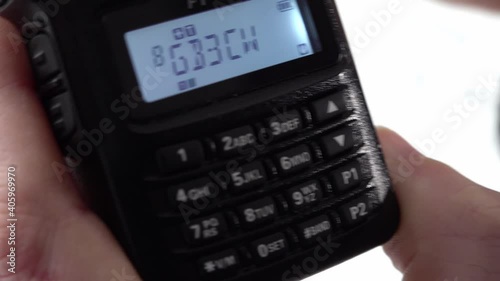 Handheld radio tuning into different frequencies and listening to broadcasts