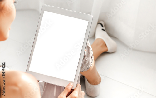 Smiling happy asian woman relaxing using tablet computer working with white mockup blank screens at home.technology and communication concept