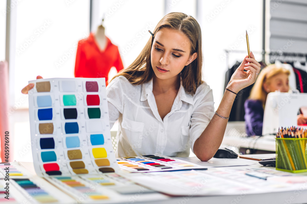 Portrait of young beautiful pretty woman fashion designer stylish sitting and working.Attractive young girl use desktop conputer and colorful fabrics at fashion design studio - obrazy, fototapety, plakaty 