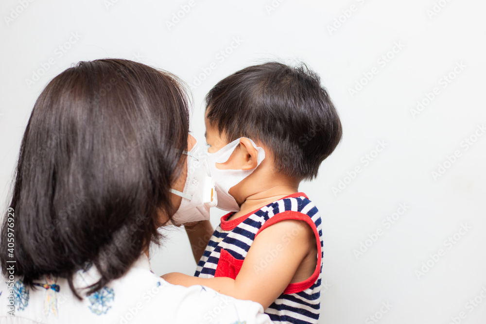 Mother hold baby boy wear medical face mask protect from infection of virus Mother hold baby boy wear medical face mask protect from infection of virus