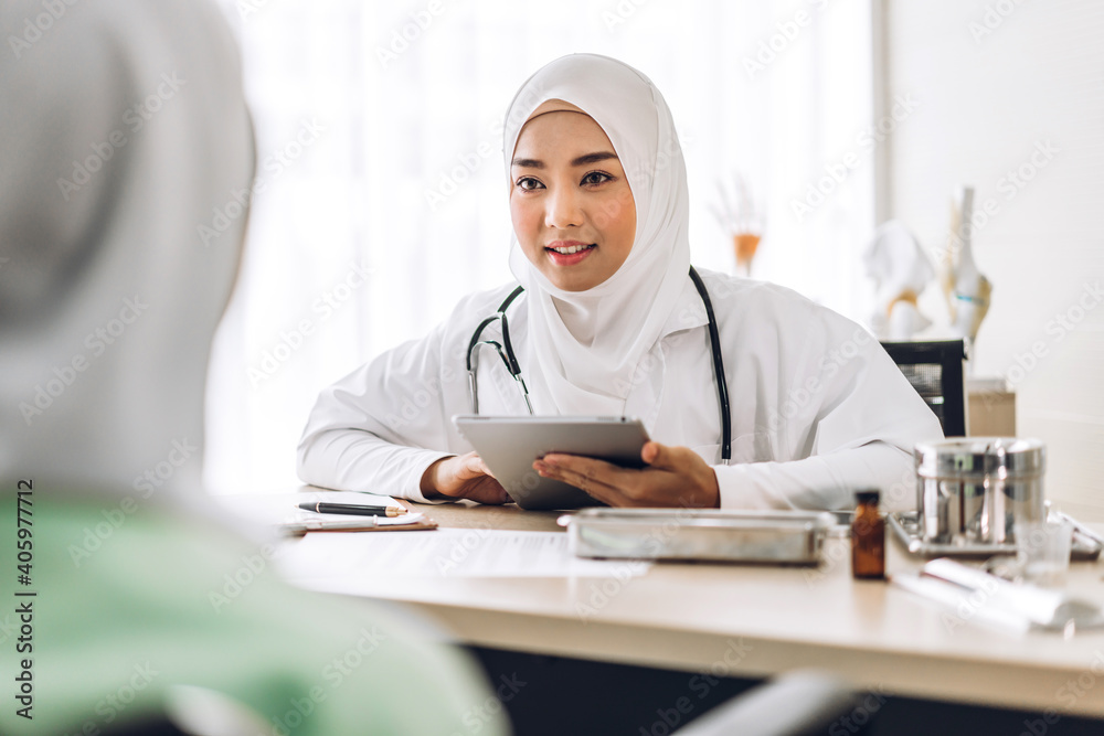 Muslim asian woman doctor service help support discussing and consulting talk to muslim woman patient at meeting health medical care express trust concept in hospital.healthcare and medicine Muslim asian woman doctor service help support discussing and consulting talk to muslim woman patient at meeting health medical care express trust concept in hospital.healthcare and medicine