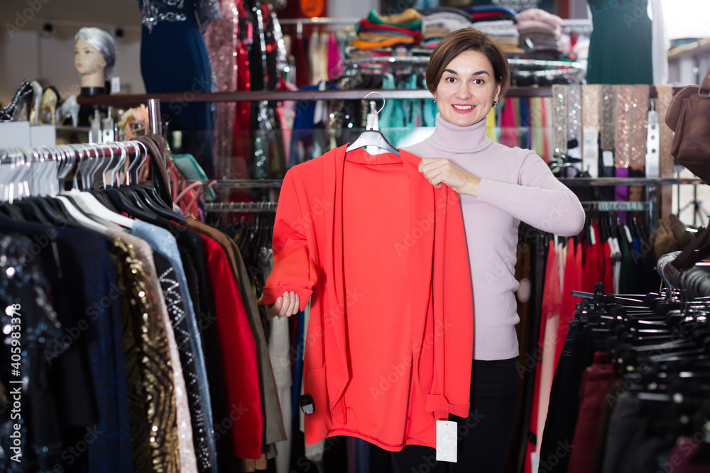Adult female customer deciding on jersey cardigan in women cloths shop