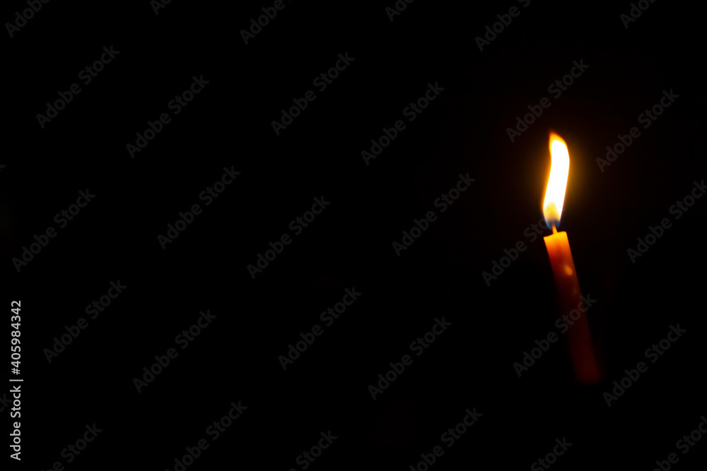 light candle in the darkness on the black background. light candle in the darkness on the black background.