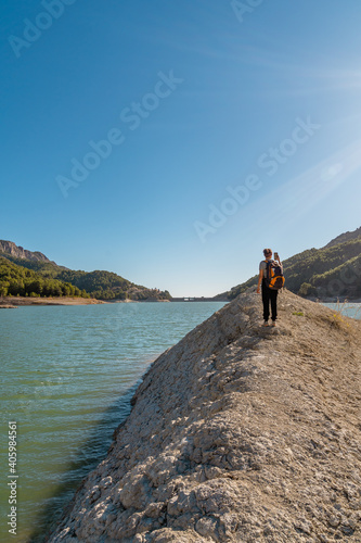 Vertical shot of a female tourist taking a photoof the Guadalest reservoir in Alicante, Spain photo