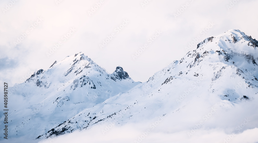 Panoramic view of mountains near Brianson, Serre Chevalier resort, France. Foggy winter mountain landscape. Ski resort landscape. Snowy mountains. Winter vacation. Misty morning in mountains