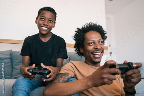 Father and son playing video games together at home.