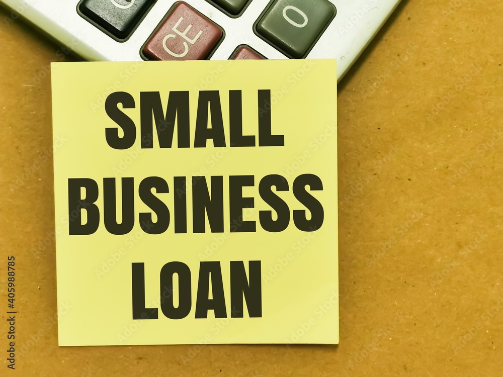 Text SMALL BUSINESS LOAN written on yellow paper note on calculator.Business concept. Text SMALL BUSINESS LOAN written on yellow paper note on calculator.Business concept.