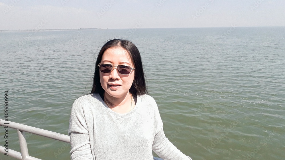 Woman standing beside the sea of holiday vacation in Thailand.