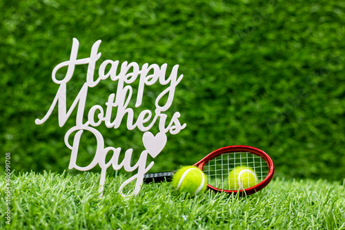 Tennis Mother's Day with tennis ball and racket on green grass background